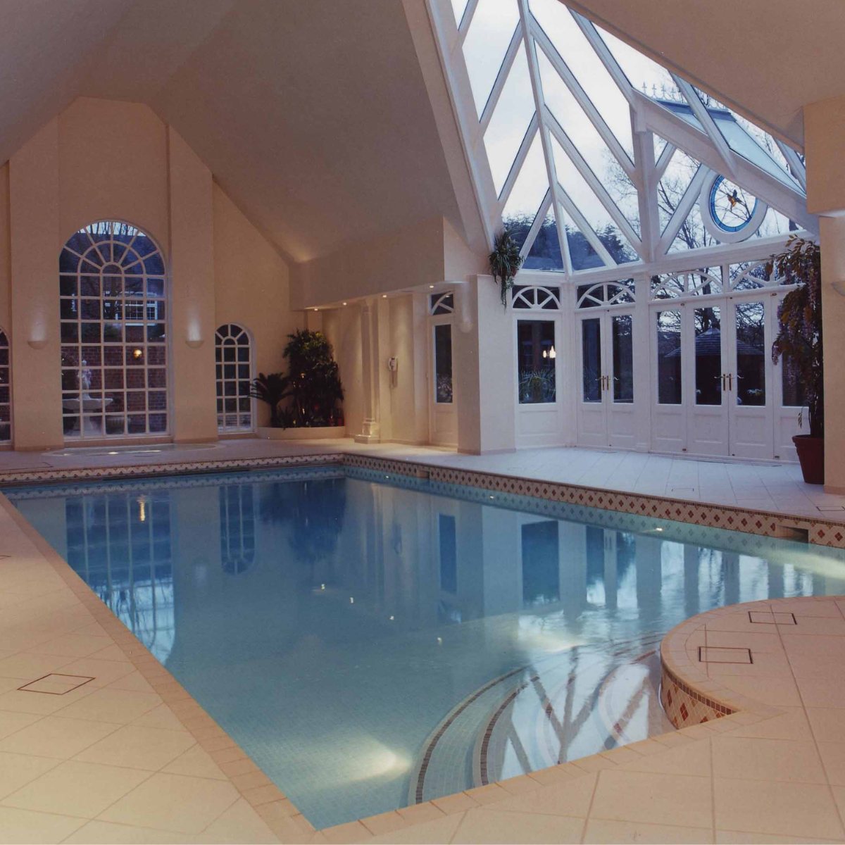Indoor pool beneath a vaulted glazed conservatory roof